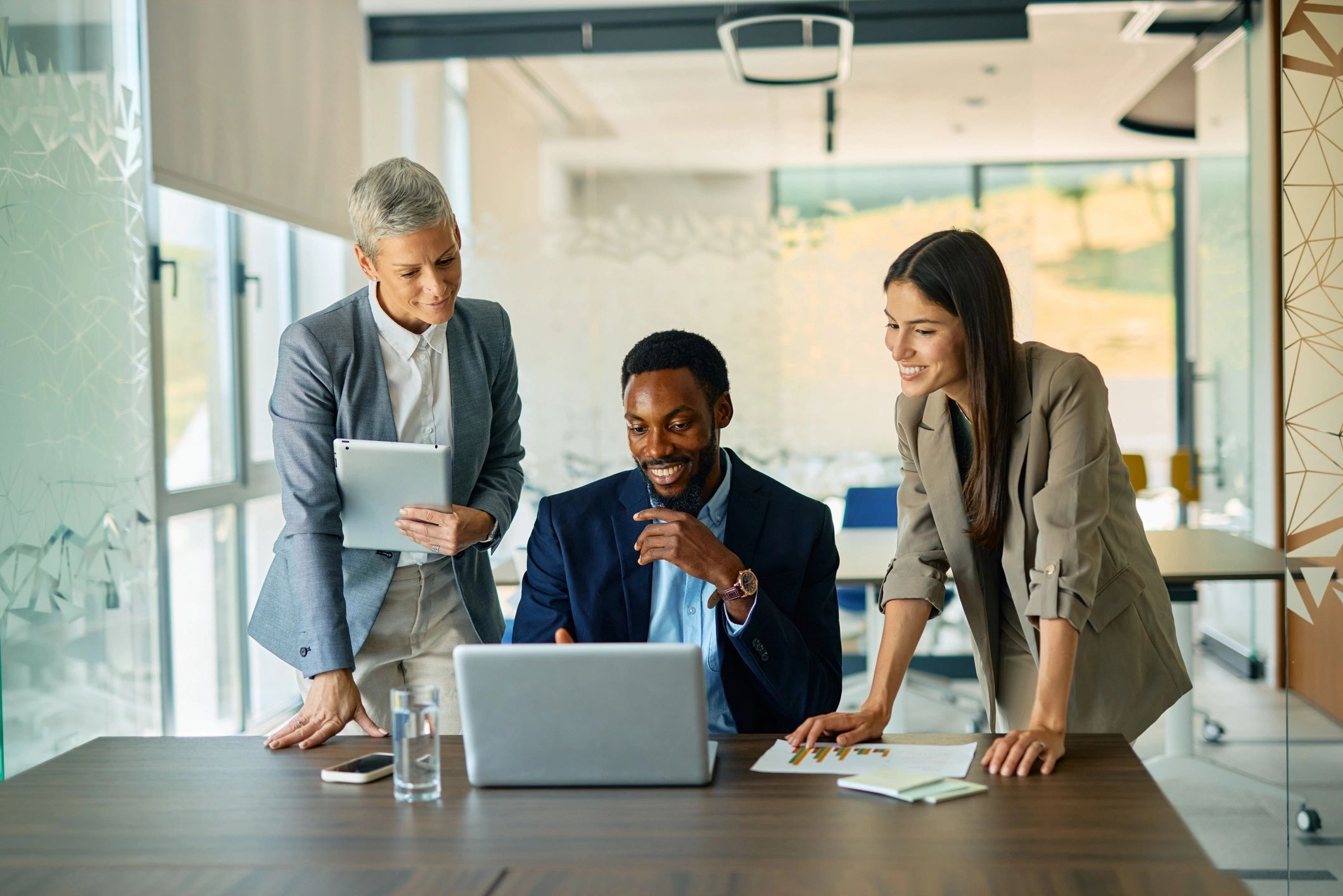 Professionals collaborating around a laptop in an office