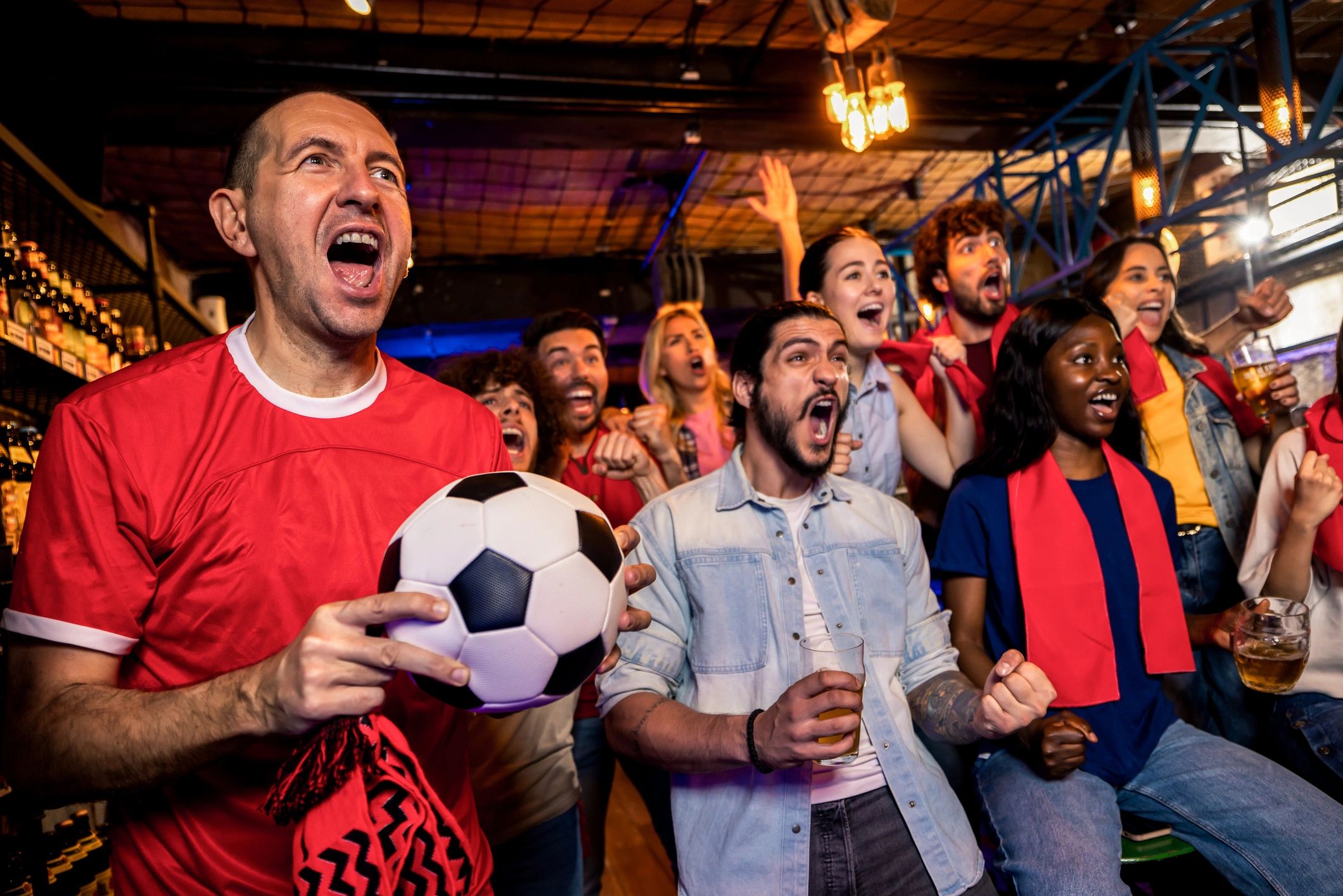 Friends cheering while watching a soccer game